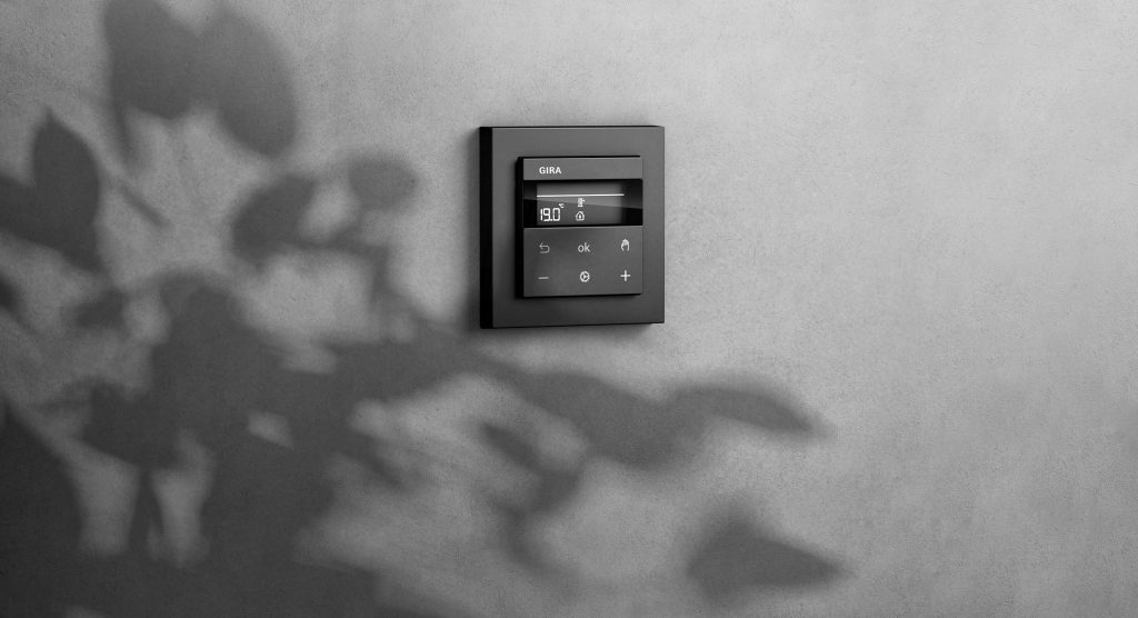 Mit dem neuen Raumtemperaturregler werden die drei Funktionen Lichtsteuerung, Jalousiesteuerung und Heizungssteuerung in einem System gebündelt. (Bild: Gira)